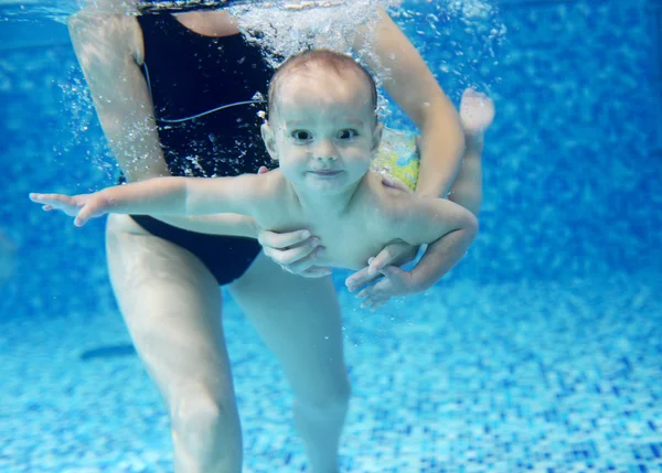 Маленький мальчик, учащийся плавать в бассейне — стоковое фото