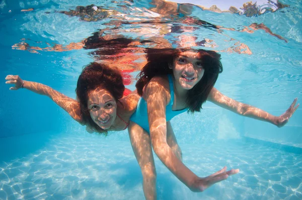 Мать и дочь, весело проводящая время под водой в бассейне — стоковое фото