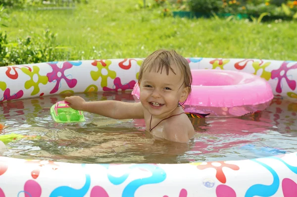2 летняя девочка купается в надувной детский бассейн и смеется — стоковое фото