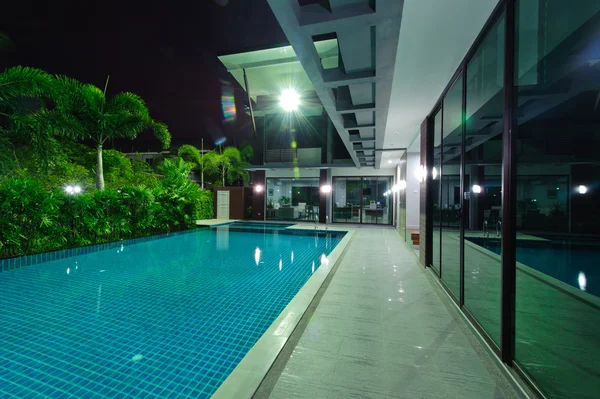 Современный дом с бассейном ночью — стоковое фото