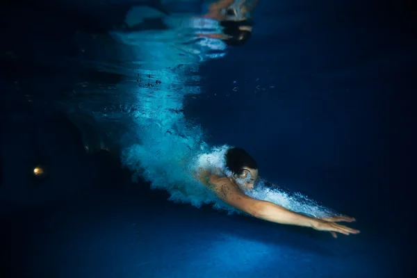 Человек, плавающий под темным открытым морем — стоковое фото