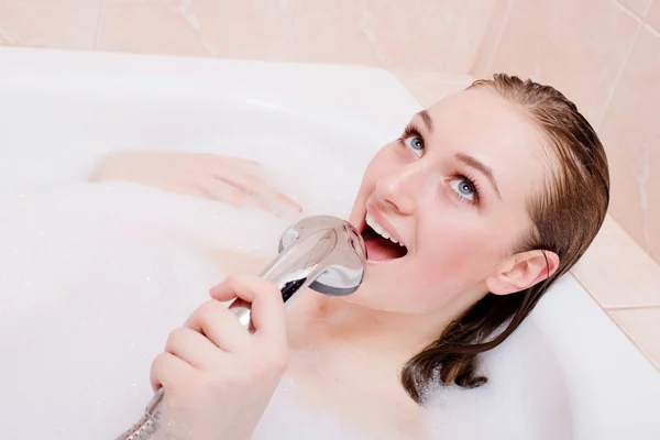 Молодая женщина в пенной ванне с удовольствием петь в душе — стоковое фото