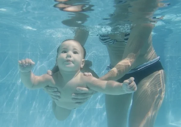 Маленький ребенок, плавающий под водой с матерью — стоковое фото
