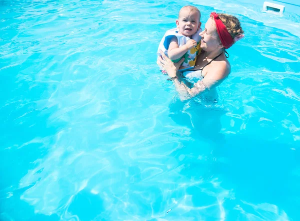 Мама, купаясь в бассейне с ребенком — стоковое фото