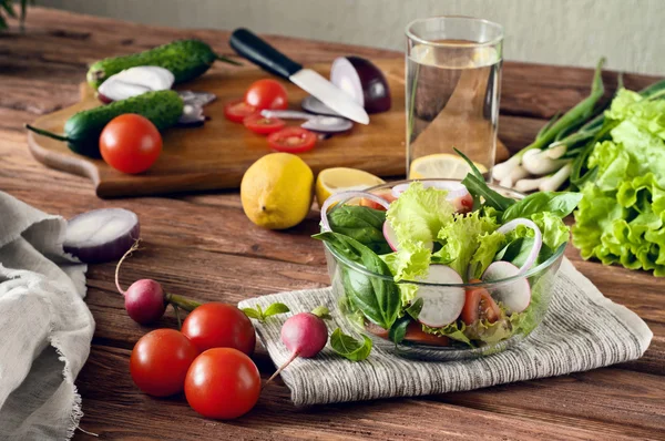 Свежий салат со стаканом воды — стоковое фото