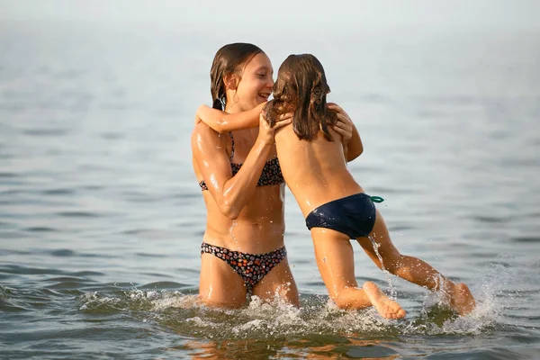 Девушки сестры весело, купание в море — стоковое фото