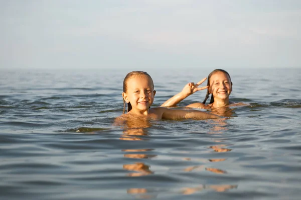 Девушки сестры весело, купание в море — стоковое фото