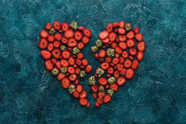 Top View Halved Heart Sign Made Ripe Strawberries Blue Concrete — стоковое фото