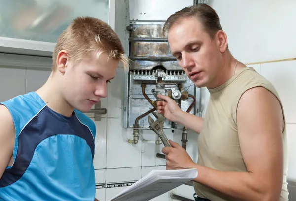 Отец и сын подросток вместе смотреть Инструкция по ремонту g — стоковое фото