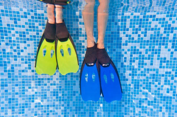 Подводный дети ноги в плавники в бассейне — стоковое фото