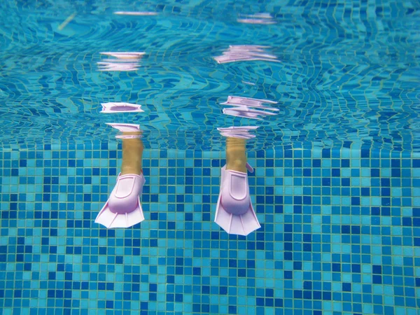 Подводный Детские ножки в плавники в бассейне — стоковое фото